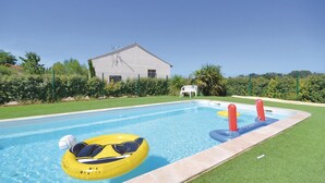 Ein Swimmingpool mit einem gelben Schwimmreifen und einem weißen Liegestuhl.