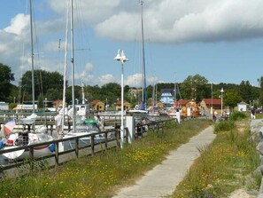 A marina with boats docked, a pathway, and buildings in the background. - Apartment 2 - Apartments in Blu Hus (Kröslin)