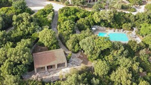An aerial view of a resort with a swimming pool, a covered outdoor seating area, and lush greenery. - Holiday apartment with air conditioning (Alghero)