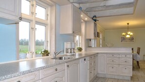 A kitchen with white cabinetry, a granite countertop, and a view of the outdoors. - Lovely home in Grindsted with house a panoramic view (Grindsted)