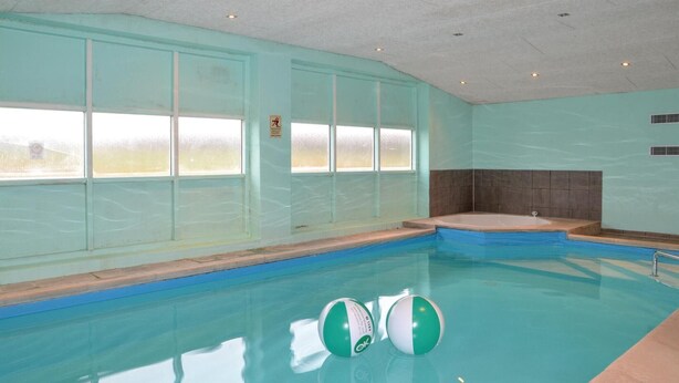 An indoor swimming pool with clear glass walls, a hot tub, and two exercise balls. - Lovely home in Grindsted with house a panoramic view (Grindsted)