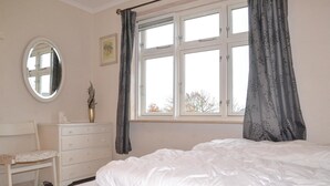 A bedroom with a bed, a dresser, a mirror, and a window with curtains. - Lovely home in Grindsted with house a panoramic view (Grindsted)