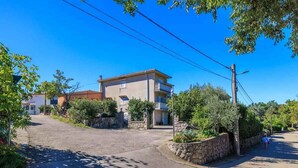 A residential street with houses, a clear sky, and a person walking. - Holiday apartment with grill and wifi (Jadranovo)