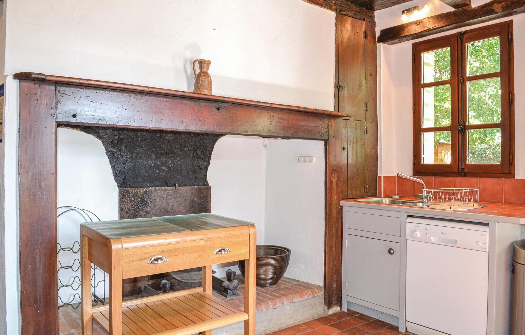 A rustic kitchen with a wooden table, a sink, and a dishwasher.