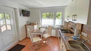 Une cuisine de taille réduite comprenant un coin repas, une fenêtre avec vue et un évier.