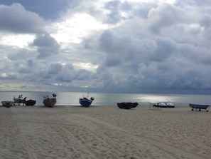 Una playa con varios barcos y una orilla arenosa.