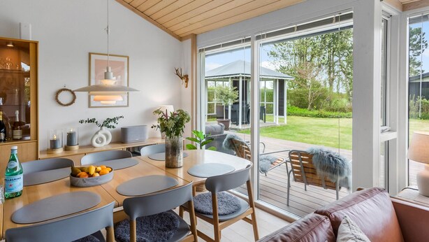A modern kitchen with a dining area, large windows, and a view of the garden. - Cozy home in Nakskov with kitchen (Nakskov)
