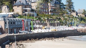 Eine Küstenlandschaft mit einer Marina, Steinhäusern und einem Strand.