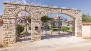 Un arco de piedra que da paso a una entrada protegida por una reja metálica.