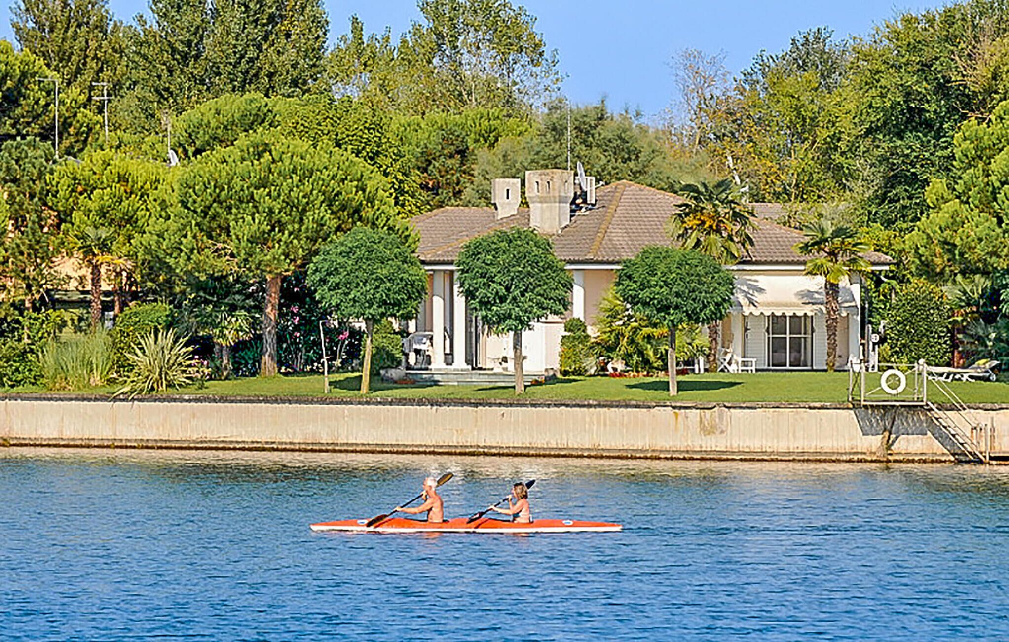 Ein Haus mit großem Rasen und einem Steg, der ins Wasser ragt.