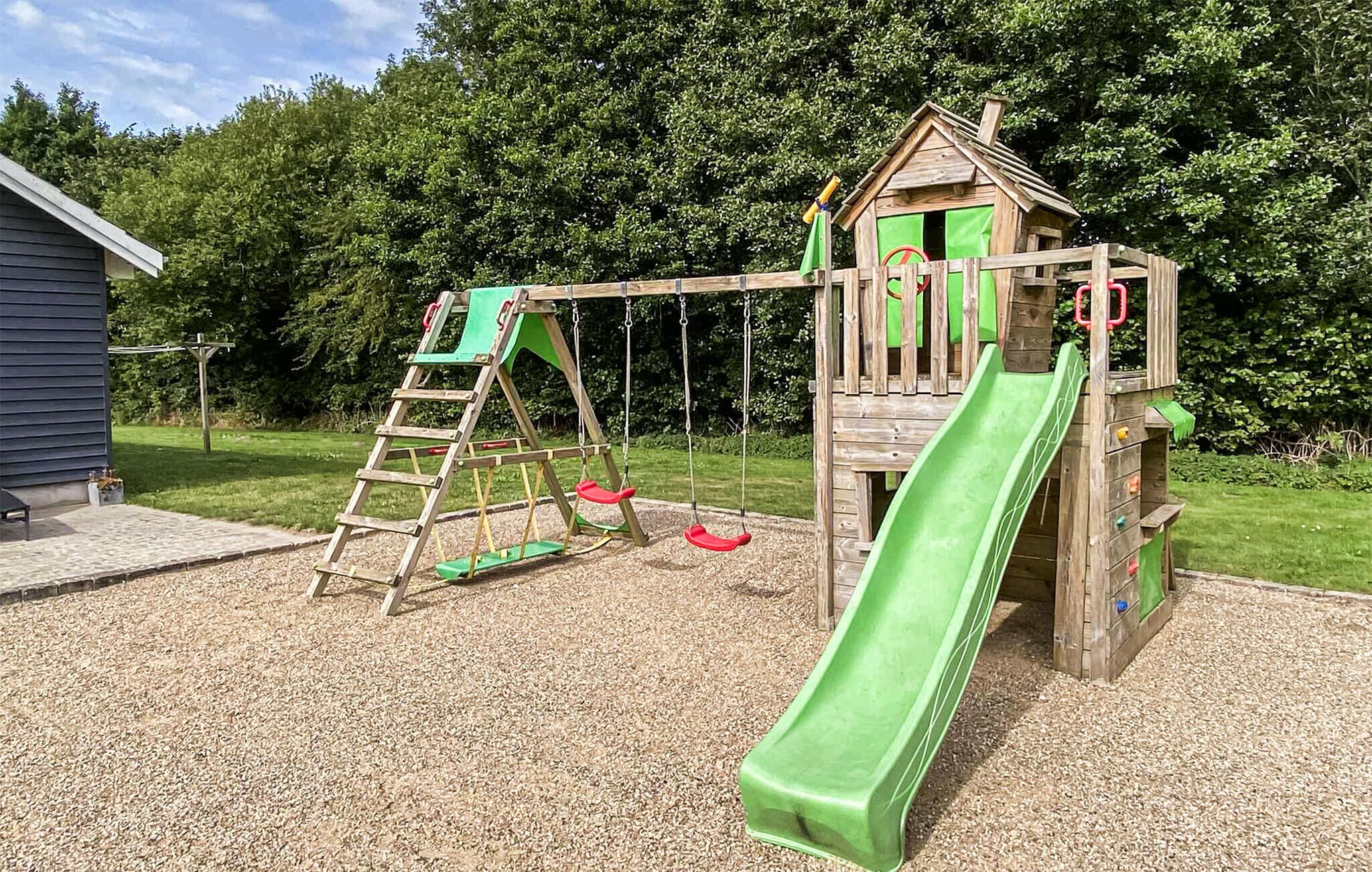 A wooden playground with a slide and swings.