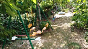 A playground with swings and a slide, surrounded by greenery. - Holiday apartment with terrace, Wi-Fi and air conditioning (Hévíz)