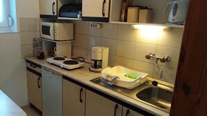 A compact kitchen with a microwave, coffee maker, and a dish rack. - Holiday apartment with terrace, Wi-Fi and air conditioning (Hévíz)