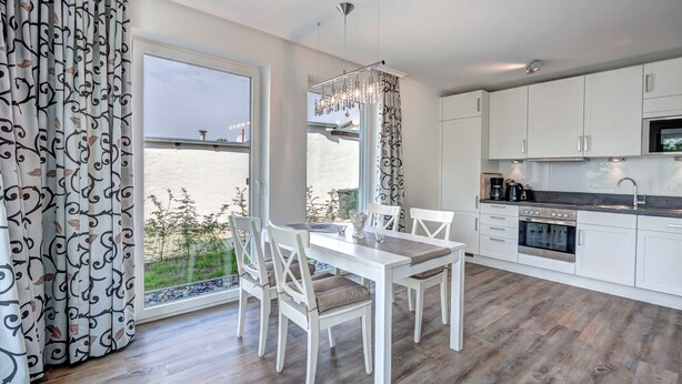 A modern kitchen with white cabinets, a built-in oven, and a stainless steel sink. - Villa Margarete Whg. 6 - Villa Margarete, BEACH NEXT (Heringsdorf)