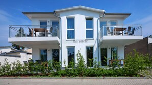 A modern two-story building with balconies, a name plaque, and a landscaped garden in front. - Villa Margarete Whg. 6 - Villa Margarete, BEACH NEXT (Heringsdorf)