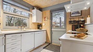Une cuisine moderne avec des armoires blanches, un four encastré et un coin café.