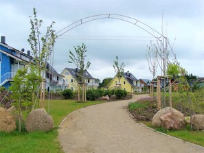 A residential area with houses, a curved pathway, and young trees.