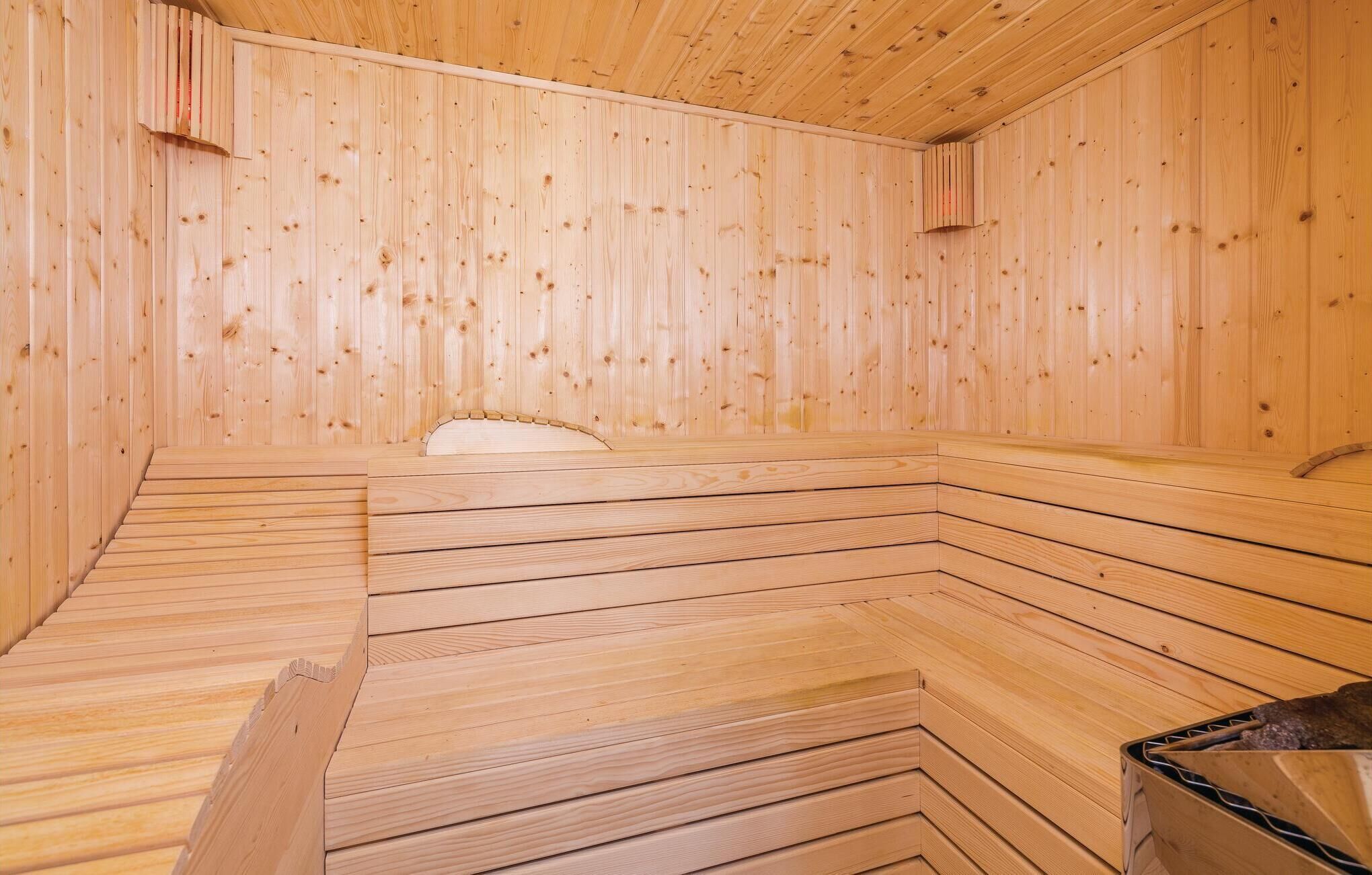A sauna room with wooden walls and benches.