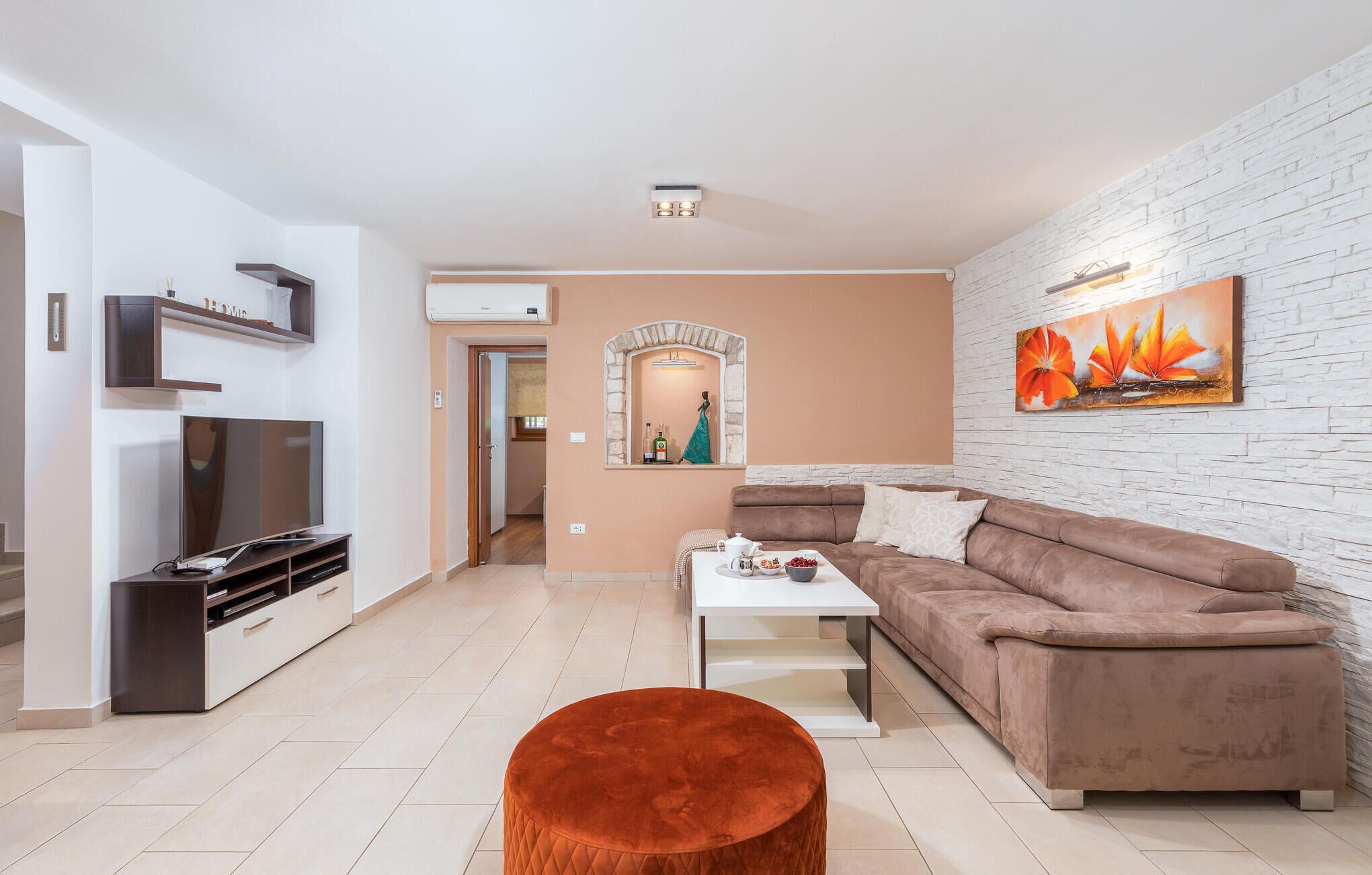 Un salon moderne avec un canapé, une table basse et un téléviseur.