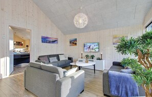 Relax in this stylish living room with a sofa, armchair, and coffee table, perfect for unwinding.