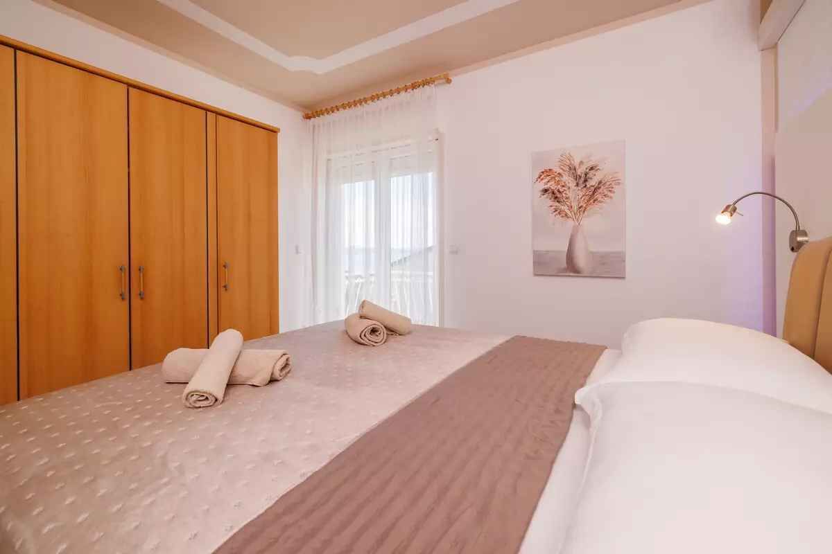 Ein Schlafzimmer mit einem Bett, einem Holzschrank und einem Bild an der Wand.