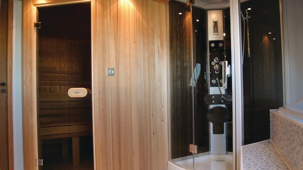 A sauna with a wooden interior and a glass-enclosed shower area.