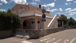 Un bâtiment à deux étages, doté d’une façade en pierre, d’un balcon avec des balustrades blanches et d’une enseigne indiquant le nom « Jesenovica ».