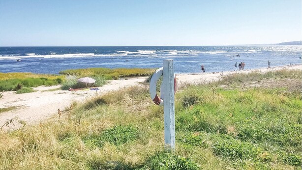 A beach with a wooden post, a sandy path, and the ocean in the background. - 2 bedroom amazing apartment in Gudhjem (Gudhjem)