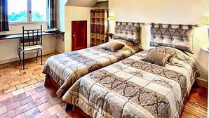 Un dormitorio con dos camas, un escritorio y una silla.