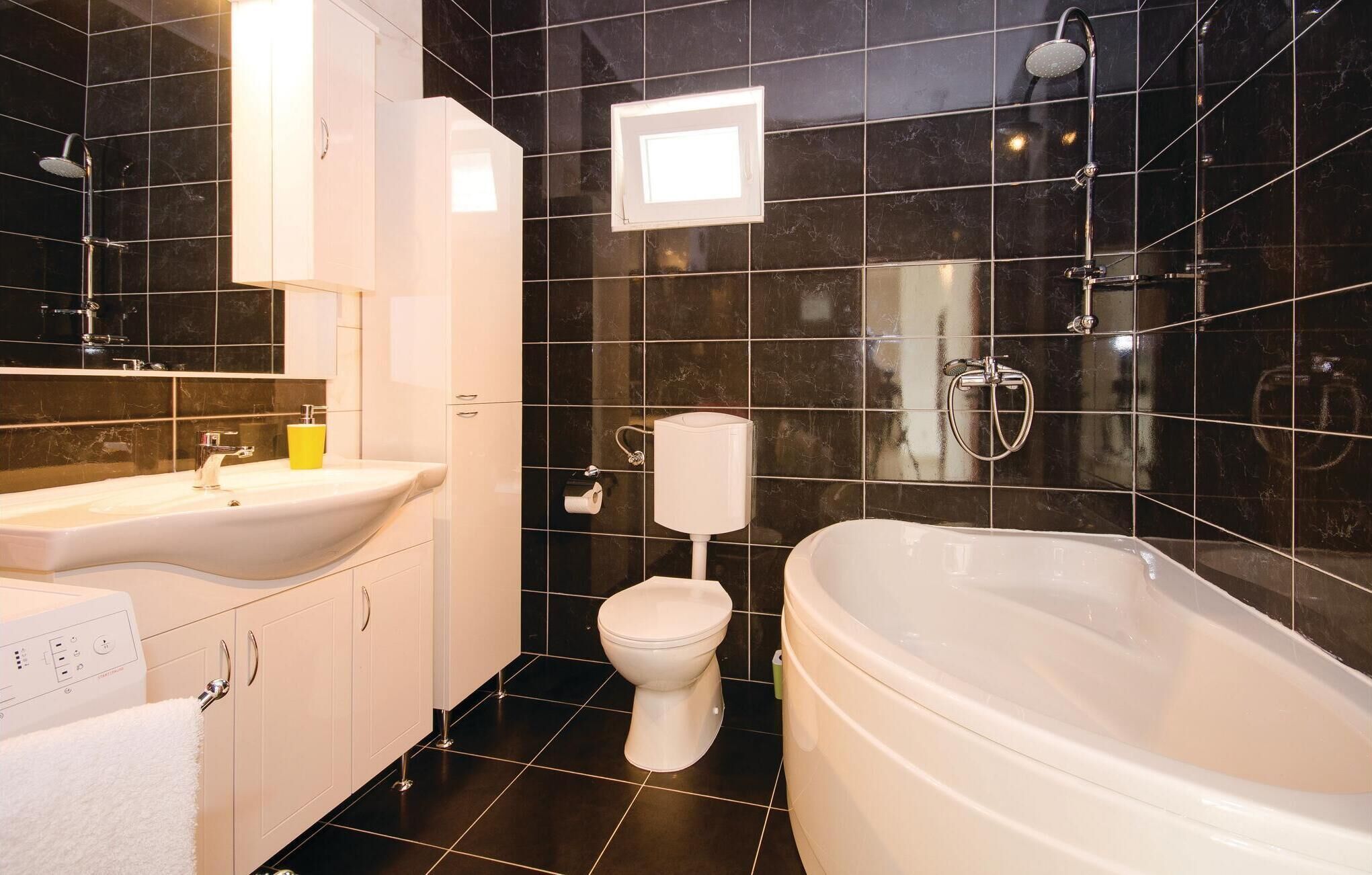 A modern bathroom with a bathtub, a toilet, and a sink.