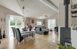 Ein großzügiger Wohnbereich mit Esstisch, Sofas und Kamin.