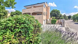 Un bâtiment à deux étages, doté d’un toit plat et d’un balcon.