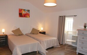 A bedroom with two beds, a painting on the wall, a window with curtains, a dresser, and a chair. - 3 bedroom awesome home in Pernes les Fontaines (Pernes les Fontaines)