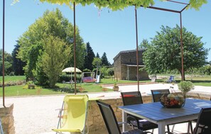 An outdoor patio area with a table, chairs, and a swing set. - 3 bedroom awesome home in Pernes les Fontaines (Pernes les Fontaines)
