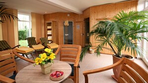 Ein Holzinterieur mit einem runden Tisch, Stühlen und einer Topfpflanze.