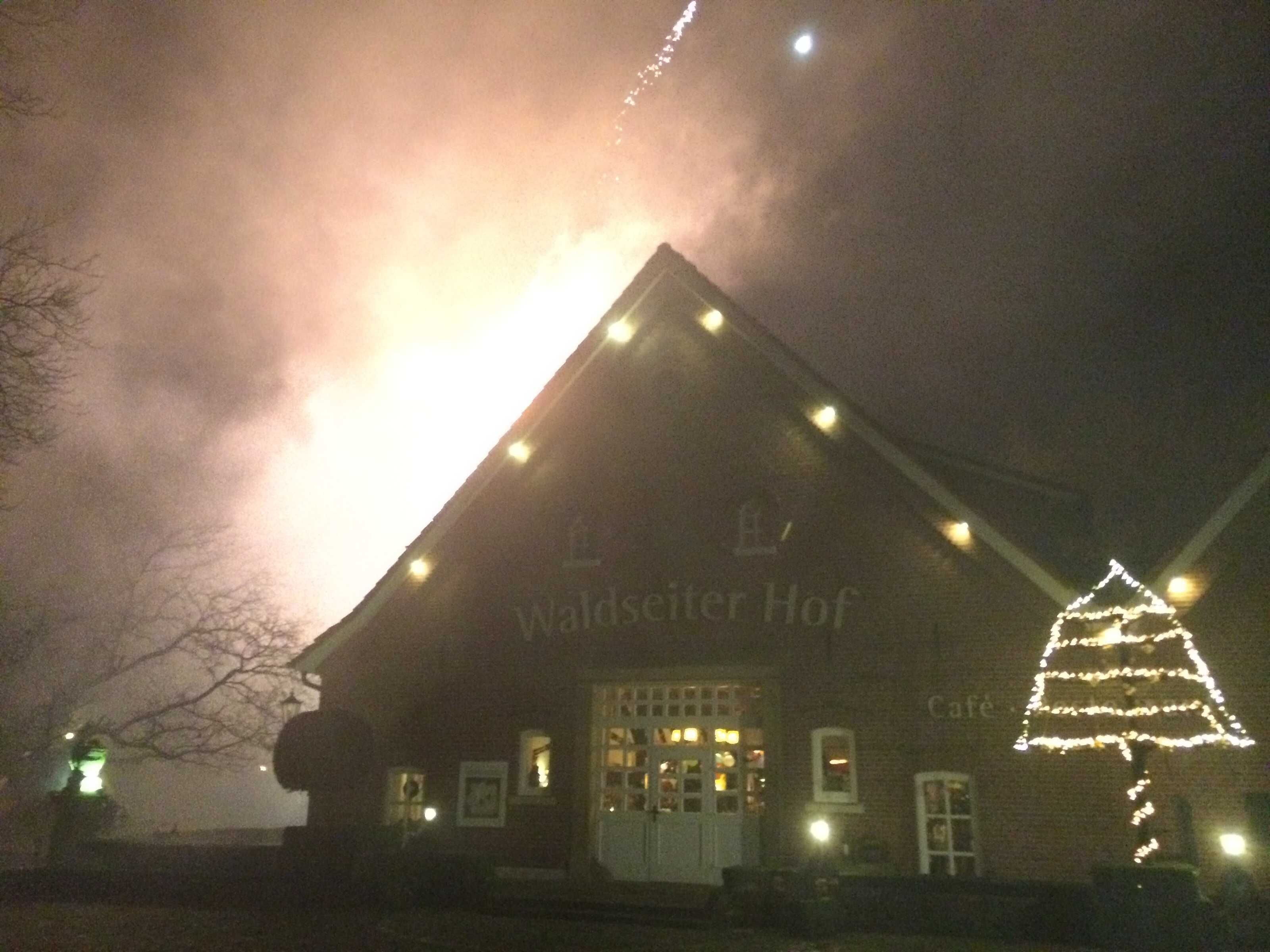 Un edificio con un letrero que dice 'Waldsäter Hof' y un árbol de Navidad con luces.