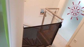 Una habitación con piso de madera, una puerta blanca y una pared con un diseño circular.