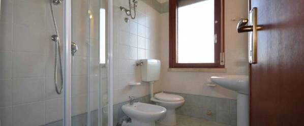 Un baño con ducha, inodoro y bidé.