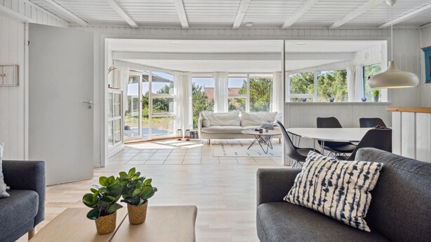 A modern living room with a grey sofa, a coffee table, and two potted plants. - Amazing home in Blåvand with WiFi (Blåvand)
