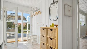 A bright room with a wicker cabinet, a mirror, and a door leading outside. - Amazing home in Blåvand with WiFi (Blåvand)