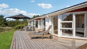 A wooden deck with outdoor furniture, a dining table, and a large umbrella. - Amazing home in Blåvand with WiFi (Blåvand)