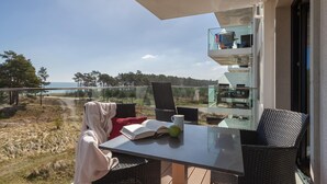 Een balkon met een tafel, stoelen en een boek.