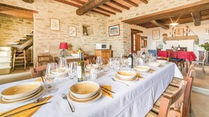 A dining area with a long table set for a meal, stone walls, wooden beams, and a staircase. - Cozy home in Castiglion F. AR (Castiglion F. AR)