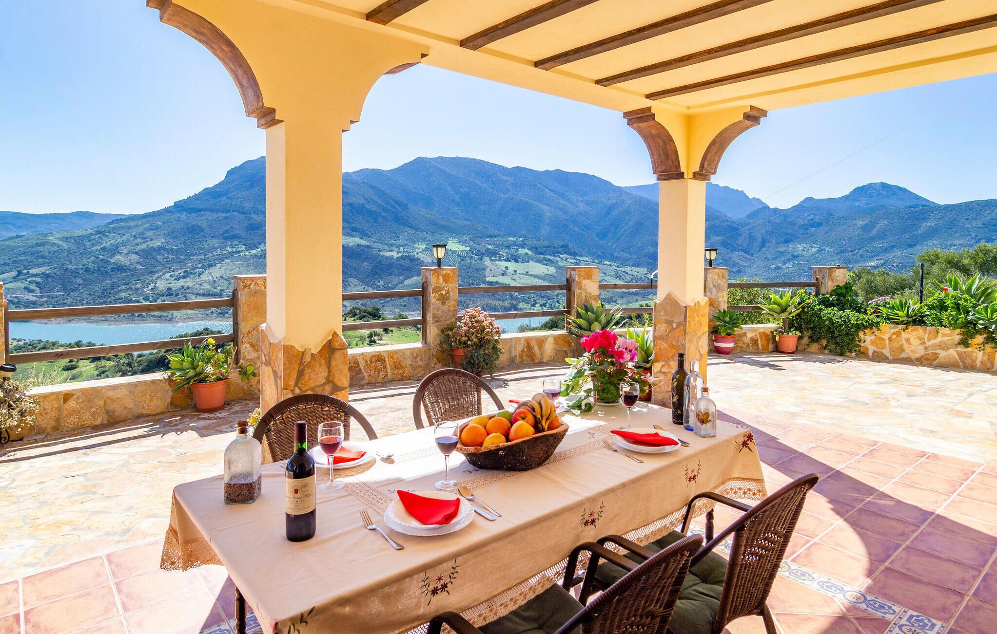 Una mesa para dos con vistas a montañas y un lago.