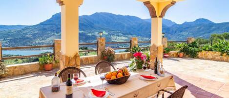 Una mesa para dos con vistas a montañas y un lago.
