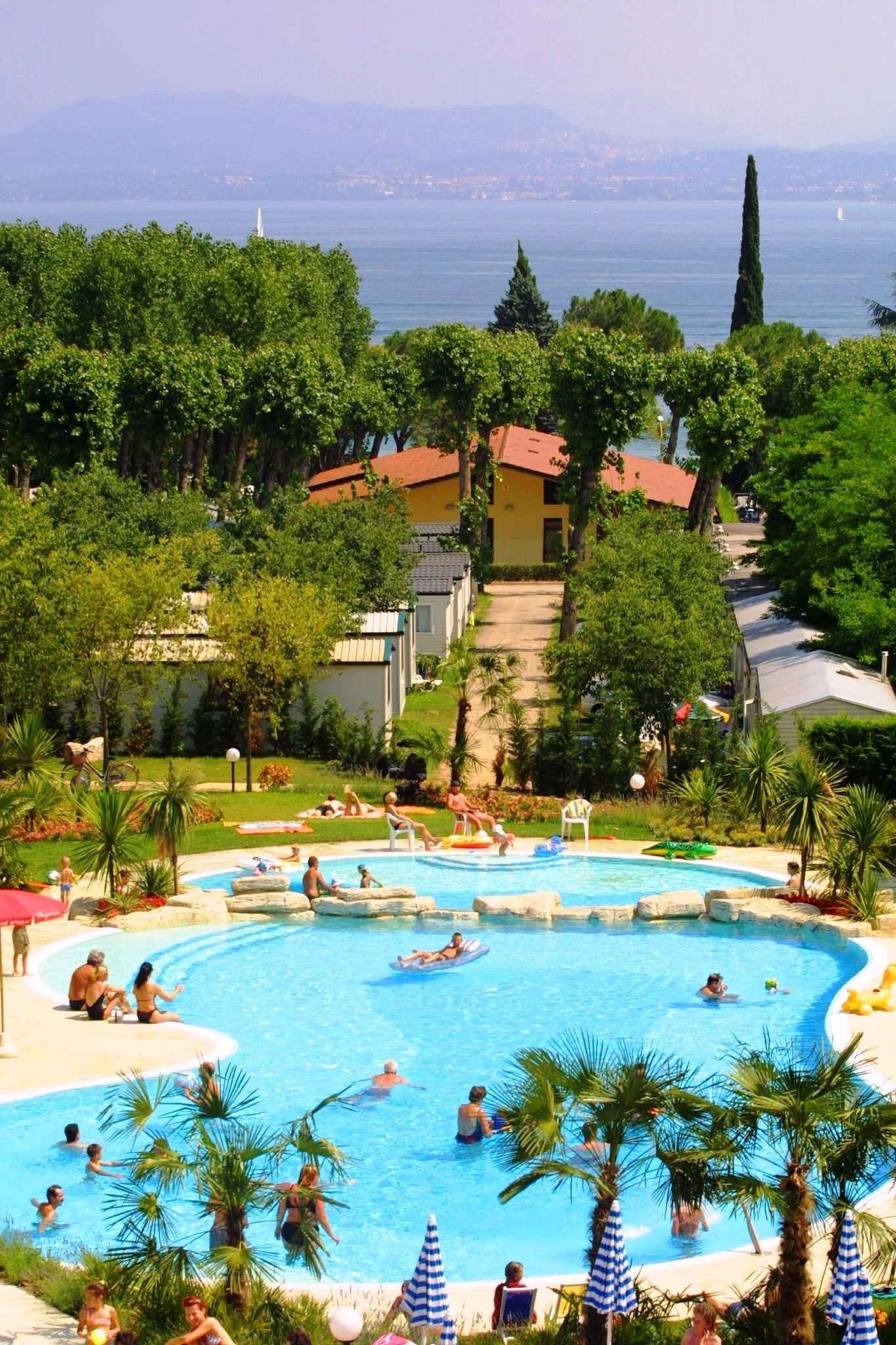 A swimming pool surrounded by lush greenery and a view of the sea.