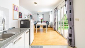 Eine moderne Küche mit Spüle, Herd und Essbereich mit Stühlen und Tisch.