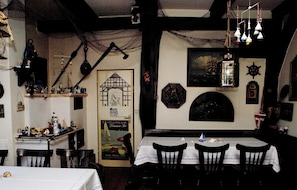A dining area with a table set for two, chairs, and various nautical-themed decorations on the walls. - Apartment "wheelhouse" - apartment / apartments (Lembruch)