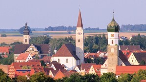 Une ville dotée d’une architecture historique, avec notamment une église surmontée d’un haut clocher et un bâtiment plus petit coiffé d’un dôme.