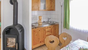 Una cocina con armarios de madera, estufa y pileta.